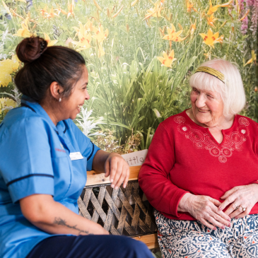 A Pennington Court carer and resident sat on a bench