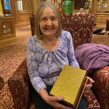 our residents took a trip down memory lane and wrote down their favourite Christmas memories – we put them in this special box (modelled beautifully here by resident Doreen) and we’re going to read them out on Christmas Day. 
